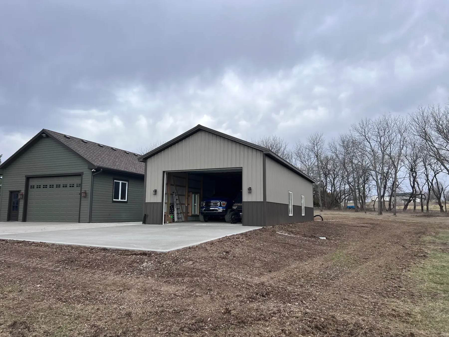 Finished graded ground and drive area beside a large shop building