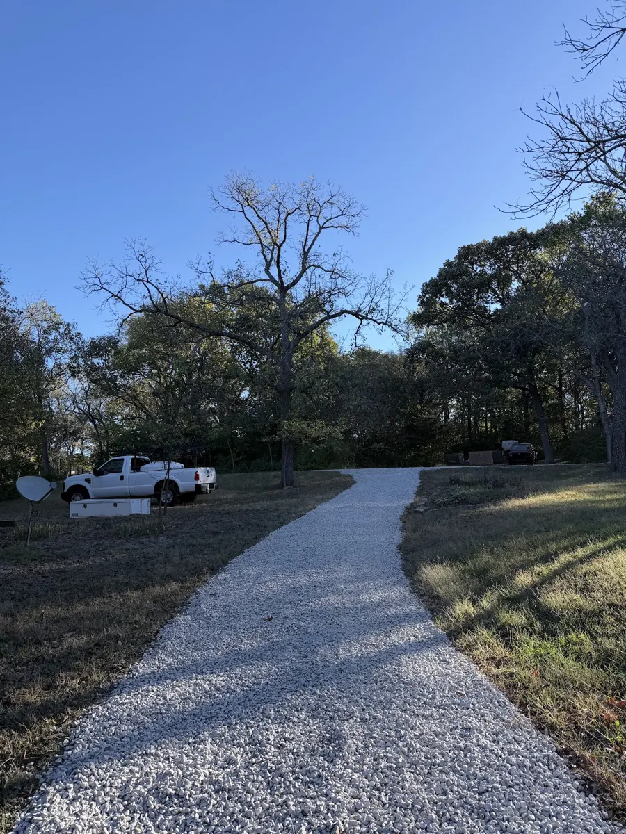 Finished white gravel driveway leading through the trees, posted by Shari Riddle