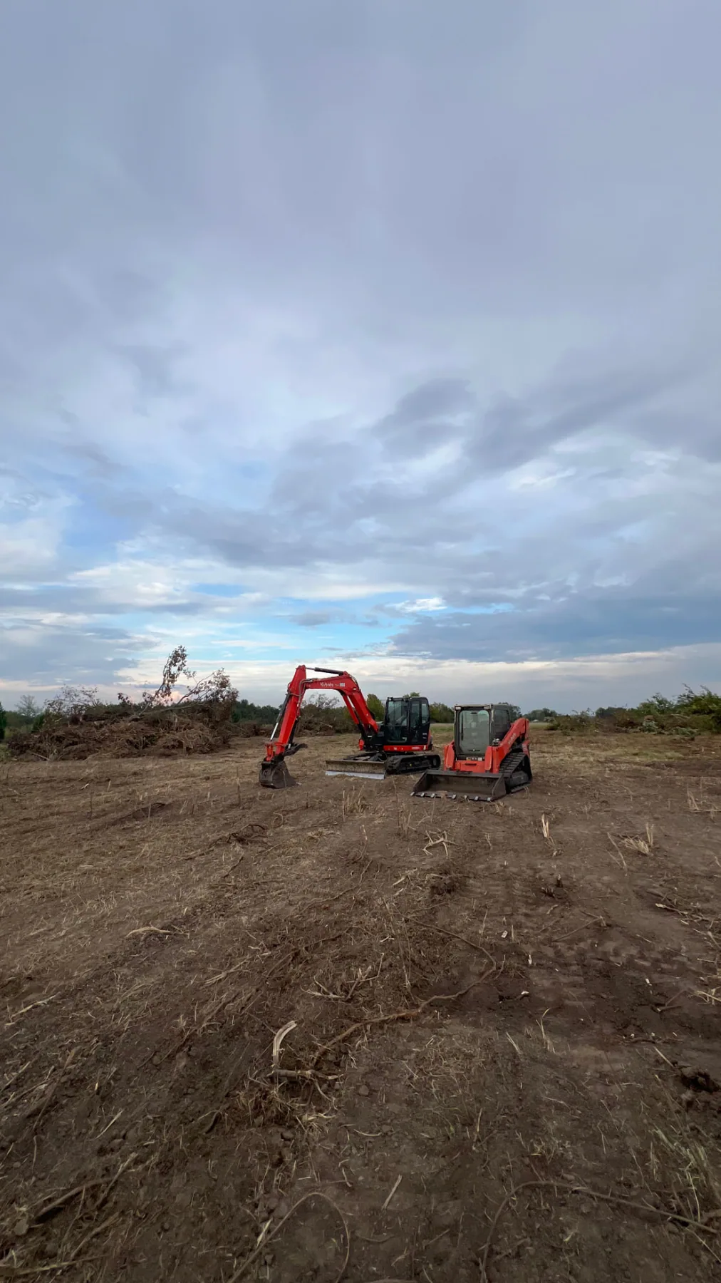 Kubota excavator and track loader on a freshly graded site preparation pad