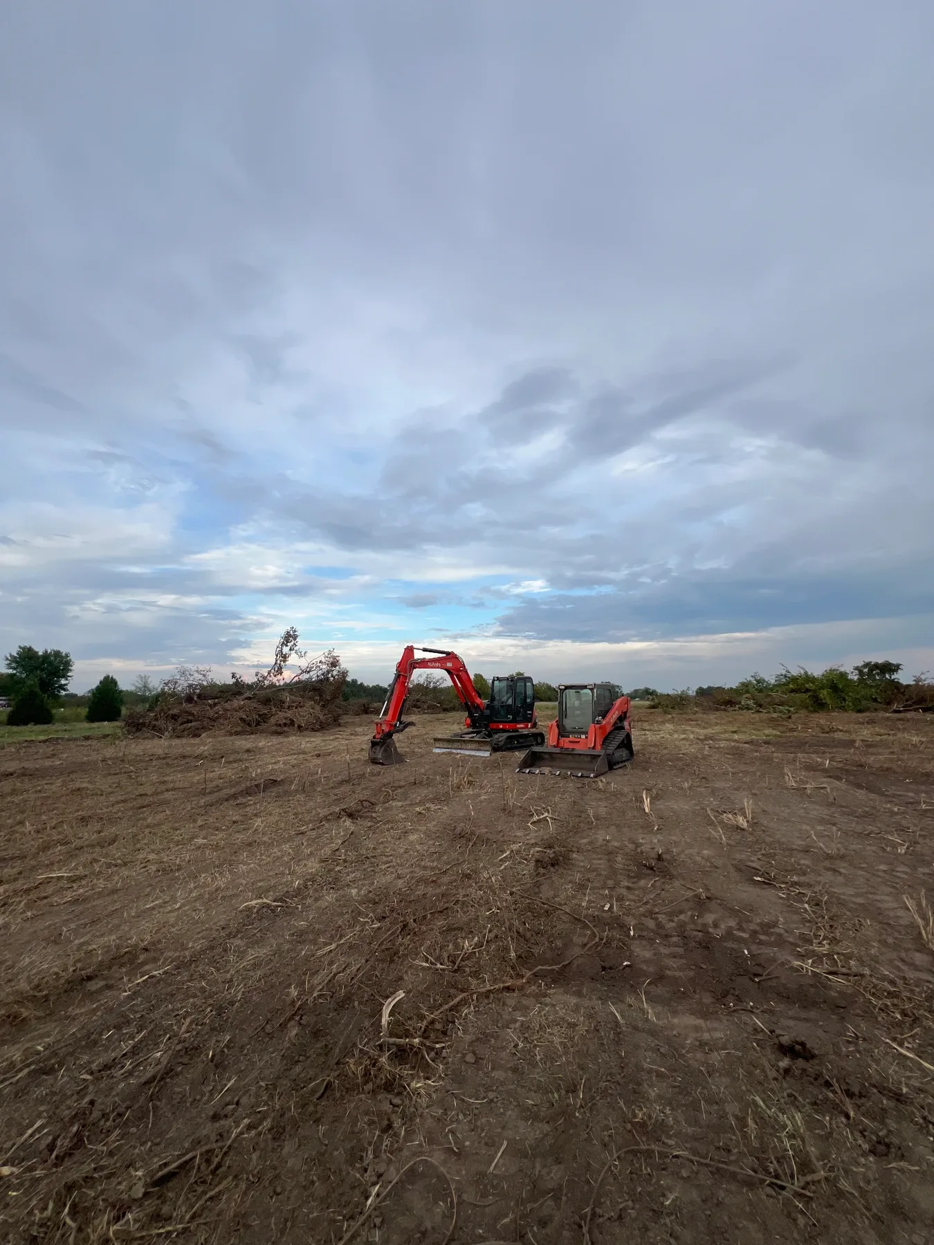 Kubota land clearing equipment working across a cleared lot