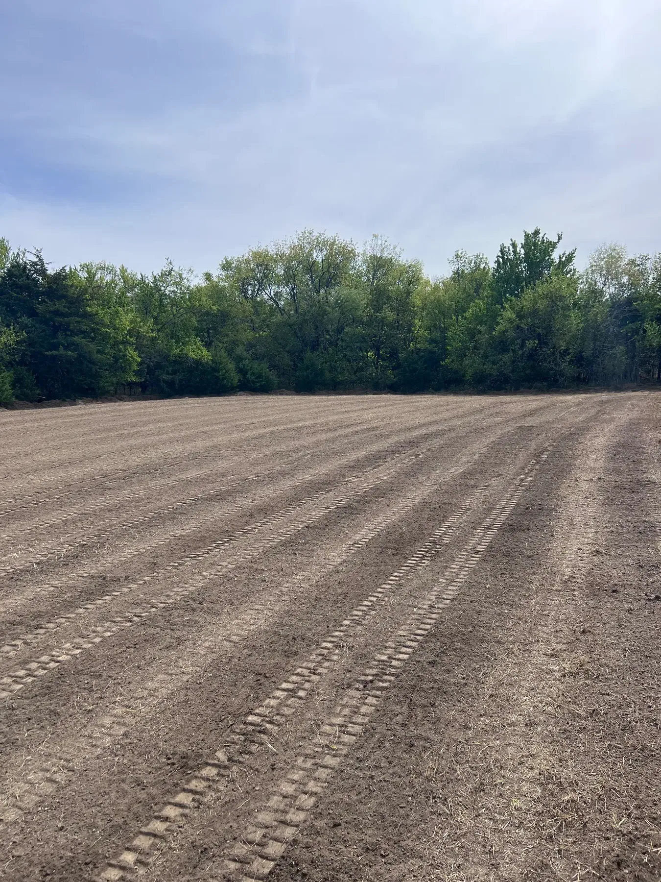 Smooth graded field with parallel equipment tracks after final grading